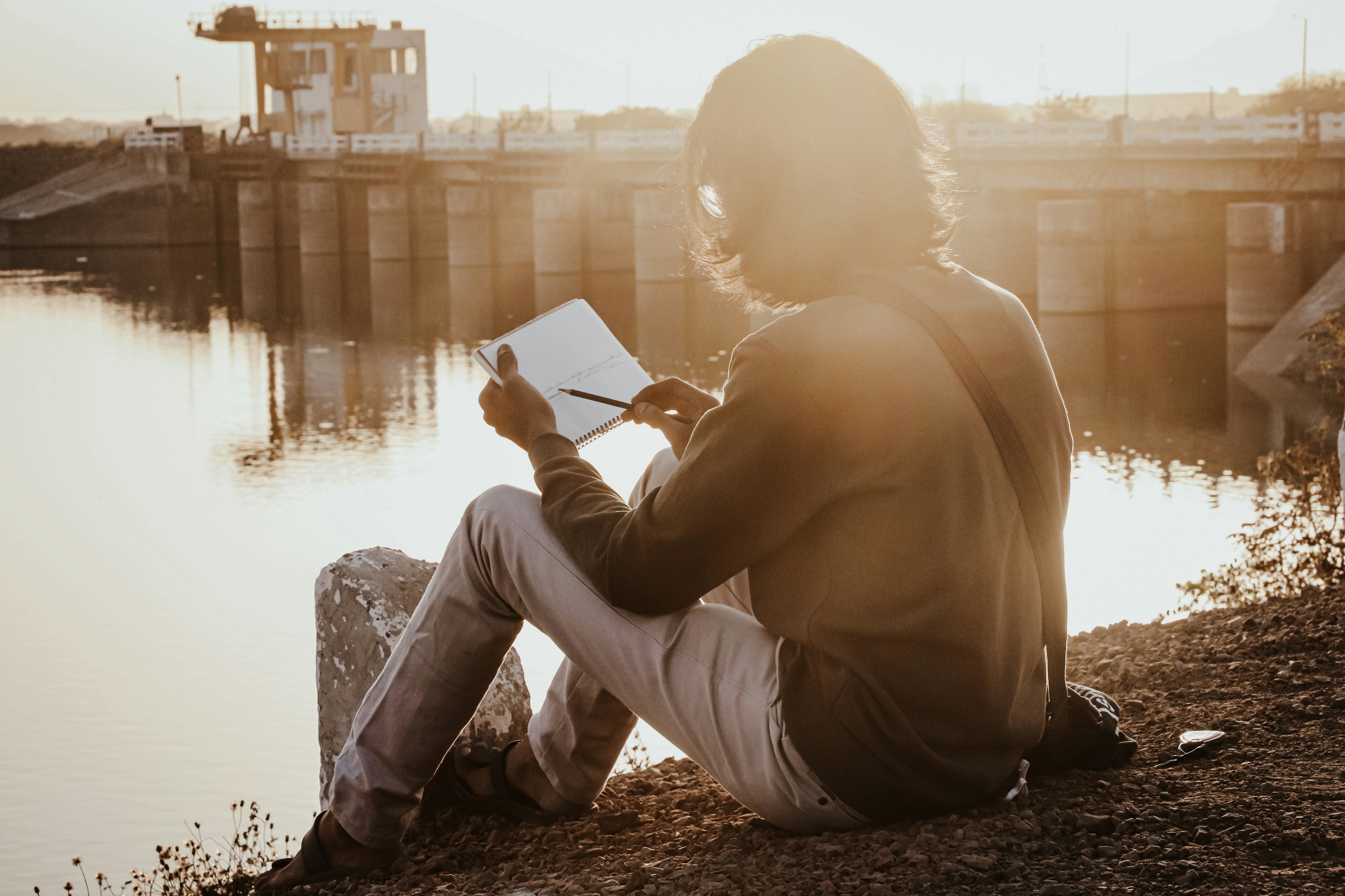 Person journaling at sunset reflecting on their journey
