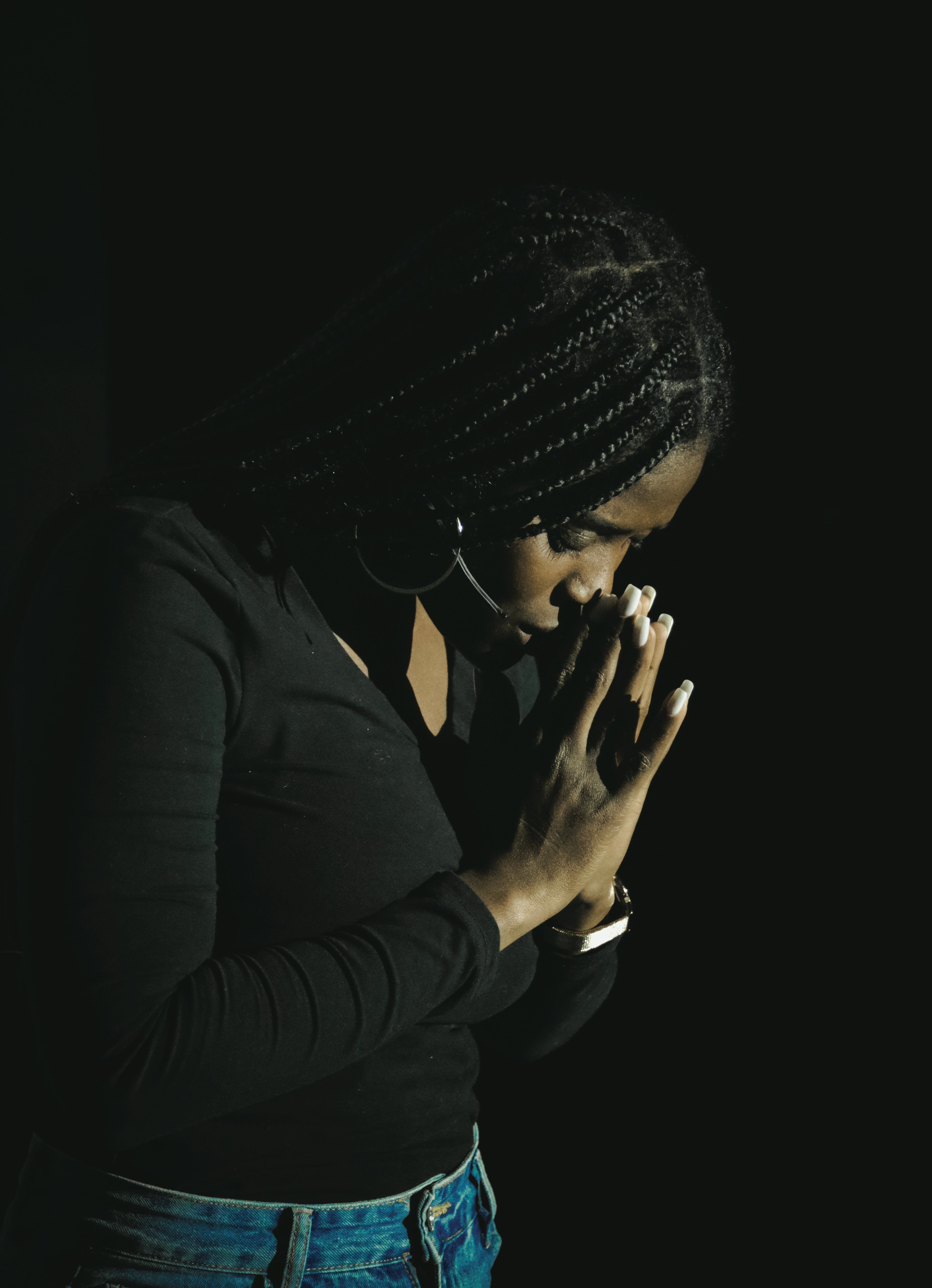 Woman praying alone in darkness seeking God