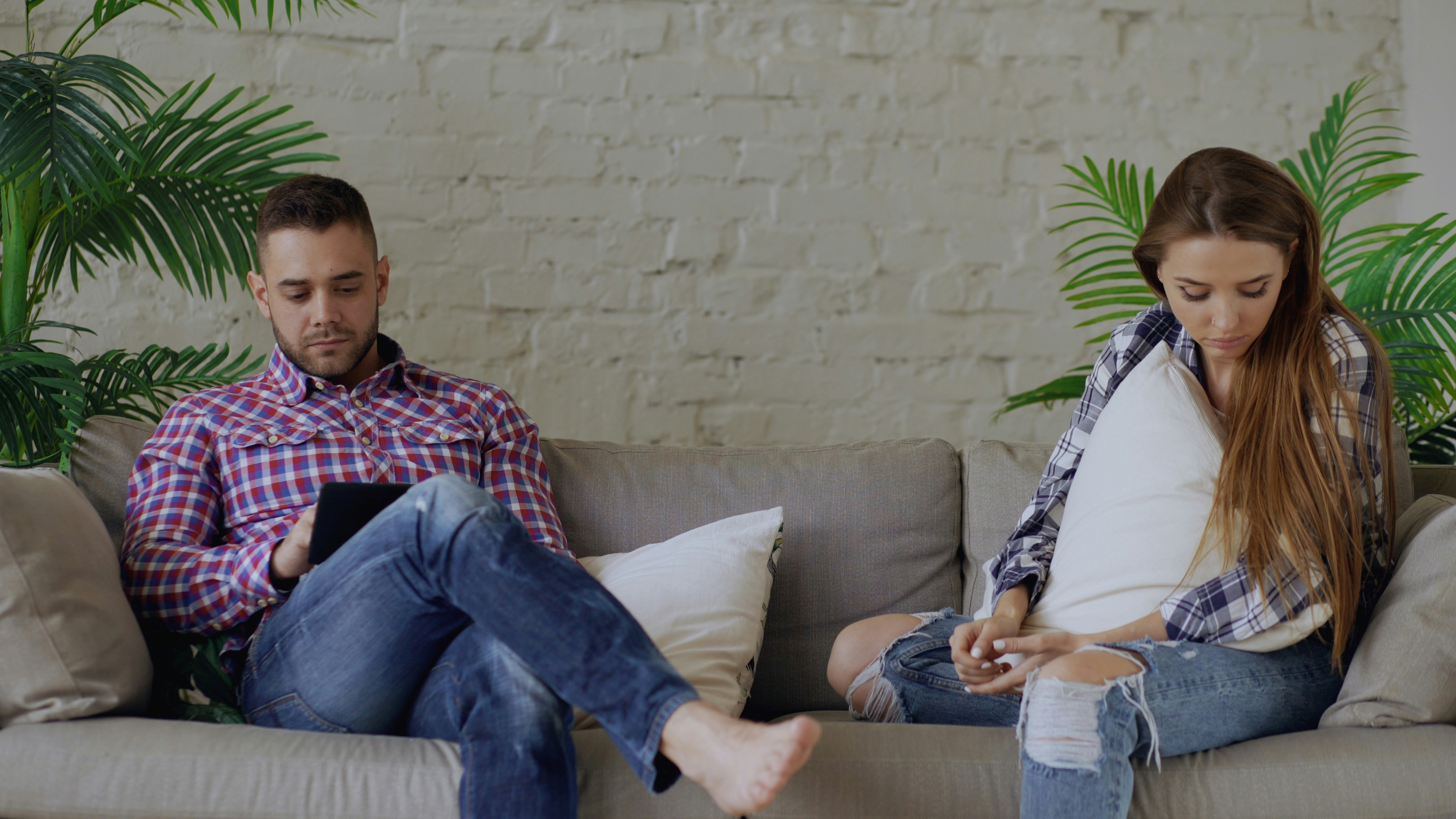 Couple sitting apart disconnected in their relationship