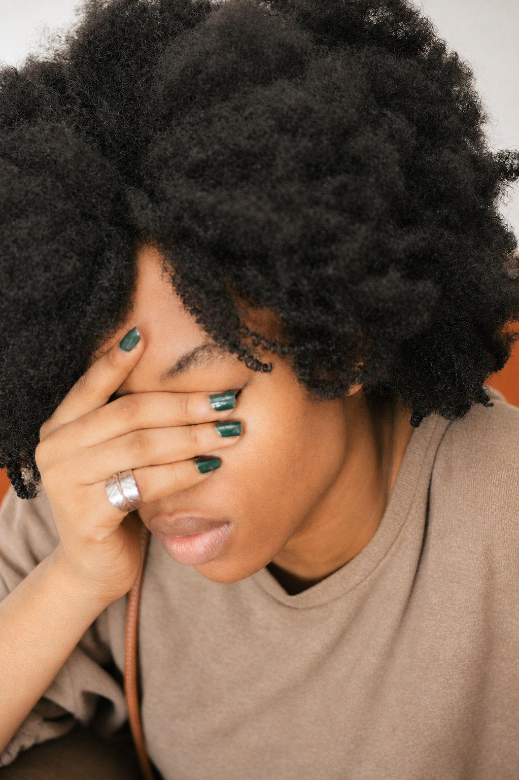 Woman overwhelmed and emotionally exhausted, hand over her face
