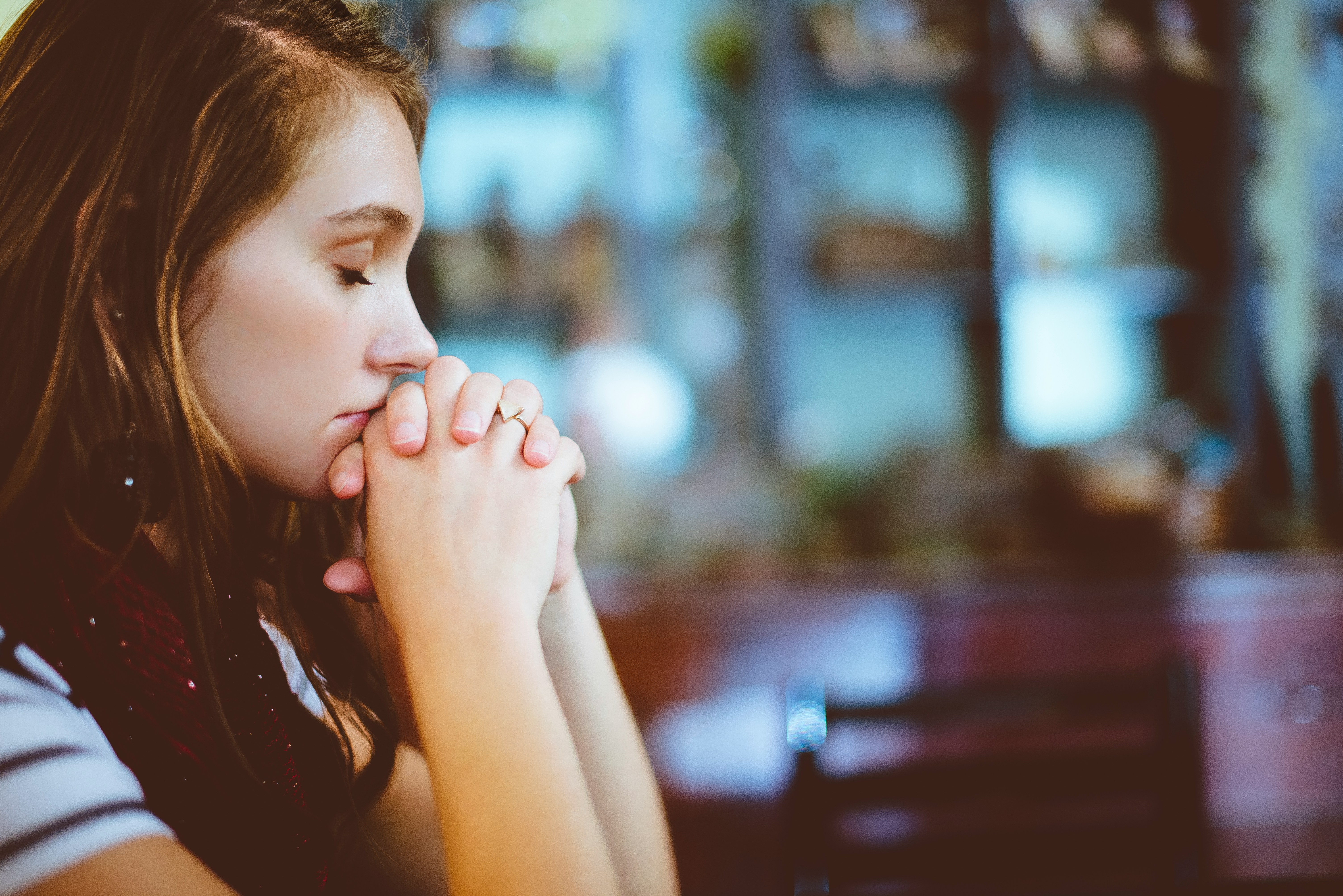 Woman praying quietly, seeking God in a moment of stillness