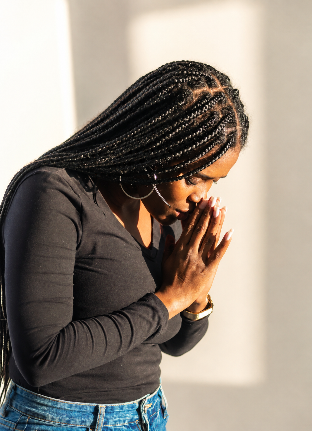 Woman with hands folded together in sincere prayer