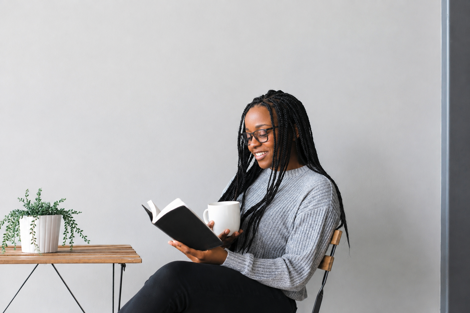 Woman smiling while reading, holding a coffee mug